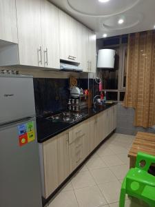 a kitchen with wooden cabinets and a refrigerator at Hay Salam Agadir in Agadir