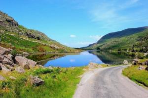 a dirt road next to a lake in a valley at Horseshoe Cottage, Killarney in Killarney +8 photos