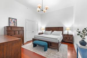 a bedroom with a bed and a blue stool at Downtown Loft- Steps away from Plant Riverside! in Savannah