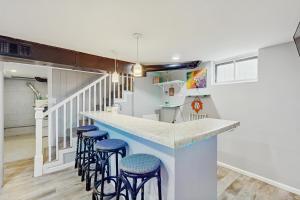 a kitchen with a counter with blue stools at Beach Bungalow Getaway in Michigan City