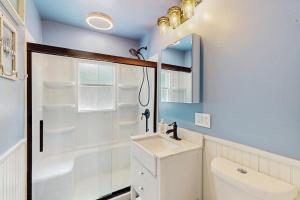 a bathroom with a toilet and a sink and a mirror at Beach Bungalow Getaway in Michigan City +16 photos