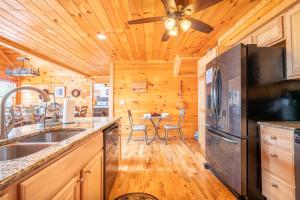 a kitchen with a refrigerator and a table with chairs at Endless Horizons By Avada Properties in Little Cove