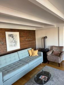 a living room with a blue couch and a chair at The History Hub by Stavanger BnB 28 in Stavanger