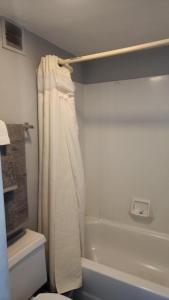 a bathroom with a shower curtain next to a bath tub at Queen Bed Hotel Room 118 in Amarillo