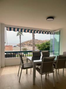 a dining room with a table and chairs and a large window at Dúplex Frente al Mar - Salobreña in Salobreña