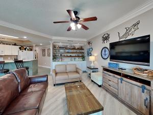 a living room with a couch and a flat screen tv at Phoenix on the Bay #1410 in Orange Beach