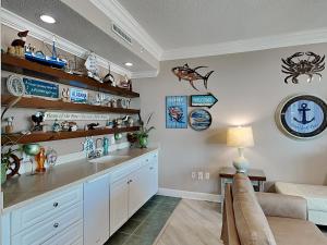 a kitchen with a sink and a couch in a room at Phoenix on the Bay #1410 in Orange Beach