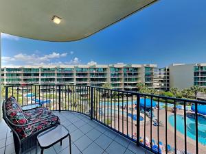 a balcony with a chair and a swimming pool at Phoenix on the Bay #1410 in Orange Beach