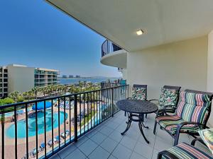 a balcony with a table and chairs and a pool at Phoenix on the Bay #1410 in Orange Beach