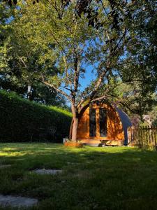 a building with a tree in the middle of a field at La Parenthèse Enchantée in Rochefort