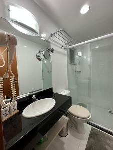 a bathroom with a toilet and a sink and a shower at Loft Porto Marina Itacuruçá in Mangaratiba
