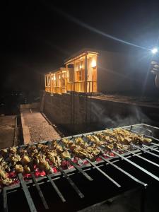 a bunch of chickens cooking on a grill at night at Yuligo Resort Skardu in Skardu