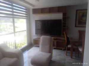 a living room with a television and a table and chairs at Espectacular apartamento acqua Hills in Dosquebradas