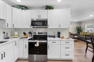 a kitchen with white cabinets and a black stove top oven at Stunning Tampa Stay - Prime Location & Comfort in Tampa