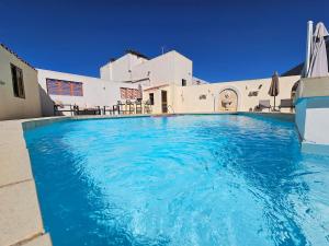 a large pool with blue water in front of a building at Peaceful escape with private pool in Mellieħa