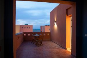 einen Balkon mit Stühlen und einem Tisch auf dem Dach in der Unterkunft Al Dora Residence Apartments in Hurghada