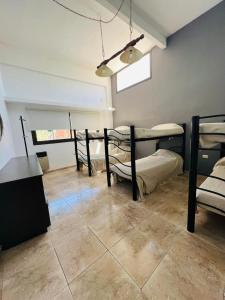 a room with four bunk beds and a tile floor at Carlos Paz Hostel Lodge in Villa Carlos Paz