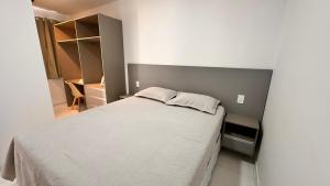 a small bedroom with a white bed and a cabinet at Dona Olivia Universidade in Vitória da Conquista