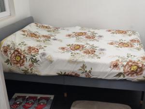 a bed with a floral blanket on top of it at Olgica lux in Pojate