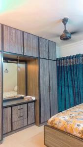 a bedroom with wooden cabinets and a bed and a mirror at SeaView 2BR with parking, Walk to Dolmen Mall & Park in Karachi +28 photos