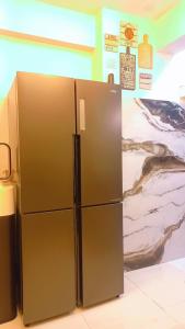 a stainless steel refrigerator in a room with a painting at SeaView 2BR with parking, Walk to Dolmen Mall & Park in Karachi