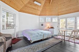 a bedroom with a bed and a table and windows at 1060-Thisted-Rodals-Bakke-21 in Torsted