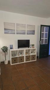 a living room with a tv and a white cabinet at Sabela Mar in Barlovento +22 photos