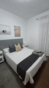 a bedroom with a large bed with blue pillows at Sabela Mar in Barlovento