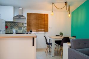 une cuisine avec un comptoir et une table avec des chaises dans l'établissement Apartamentos rurales ataecina, à Alcuéscar