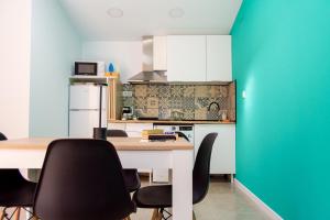 une cuisine avec une table et des chaises noires dans l'établissement Apartamentos rurales ataecina, à Alcuéscar