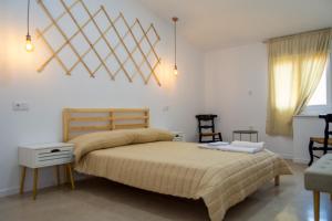 une chambre avec un grand lit et une chaise dans l'établissement Apartamentos rurales ataecina, à Alcuéscar 2 autres photos