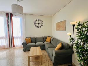 Una sala de estar con un sofá y un reloj en la pared. en Patty Flat - 15 min from Venice & Free Parking, en Venecia
