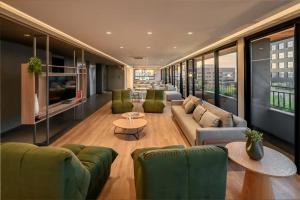a large living room with couches and a tv at Novíssimo: Go Carlos Gomes - Infra estrutura e Vista Espetacular! in Porto Alegre
