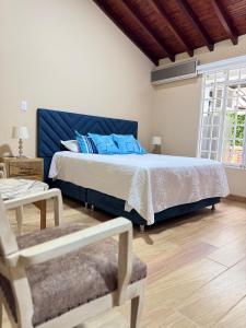 Un dormitorio con una cama grande con almohadas azules. en Casa campestre la negra, en La Tebaida