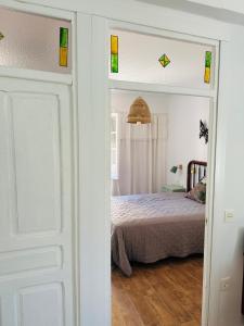a bedroom with a bed and a door with stained glass at Casa Claudio Palomar in Palomar de Arroyos