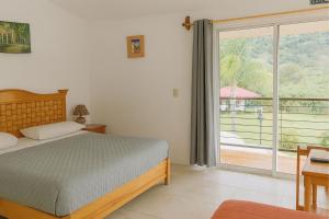 a bedroom with a bed and a view of a balcony at Hotel Brisas Del Lago in Valle de Bravo +23 photos