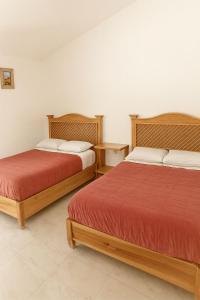 two beds sitting next to each other in a room at Hotel Brisas Del Lago in Valle de Bravo