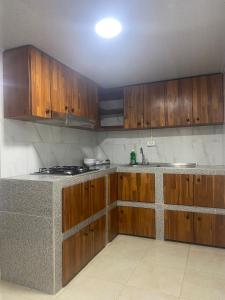 a kitchen with wooden cabinets and a counter top at FInCA LA BENDICIÓN DE SUNNYVALE in La Vega