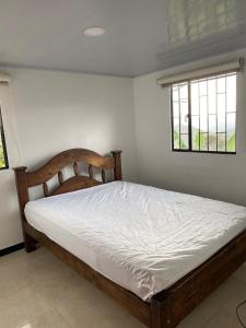 a bedroom with a bed in a room with a window at FInCA LA BENDICIÓN DE SUNNYVALE in La Vega