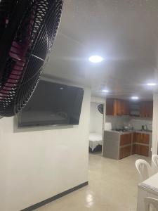 a living room with a tv and a kitchen at FInCA LA BENDICIÓN DE SUNNYVALE in La Vega +18 photos