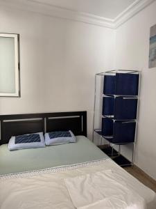 a bedroom with two beds and a shelf with blue pillows at Douja Apartment in Nabeul