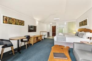 a hotel room with a bed and a table and a couch at Heritage Trail Lodge in Margaret River Town