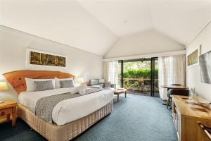 a bedroom with a large bed and a desk at Heritage Trail Lodge in Margaret River Town