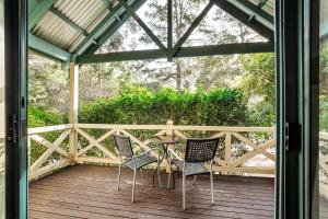 a patio with chairs and a table on a deck at Heritage Trail Lodge in Margaret River Town