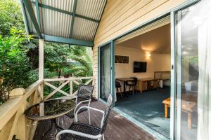 a screened porch with two chairs and a table at Heritage Trail Lodge in Margaret River Town