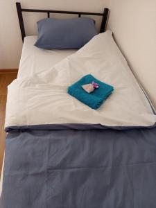a bed with a towel and a doll on it at Apartmani Piralis in Bihać