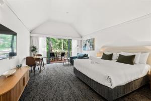 a bedroom with a large bed and a living room at Heritage Trail Lodge in Margaret River Town