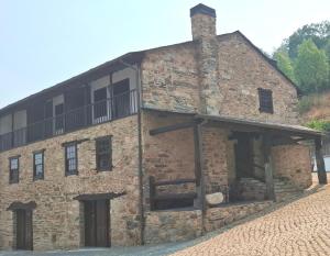 an old brick building with a balcony on the side at Casa do Lello in Bragança