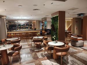 a restaurant with tables and chairs and a bar at Lindo Flat Particular em Moema em incrível Hotel administrado por gestora americana in São Paulo
