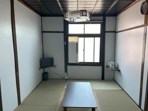 an empty room with a table and a window at 犬山口ゲストハウス in Wada